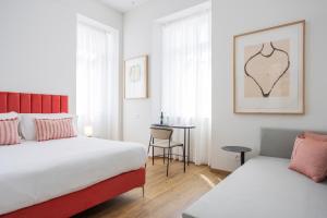 1 dormitorio con 2 camas y mesa con silla en Villa Rossella en Locarno