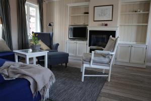 uma sala de estar com um sofá, uma cadeira e uma lareira em Holmsbu cabin 133 - cabin close to the sea em Asker