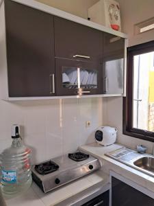 a small kitchen with a stove and a sink at Villa petit Tour in Batu