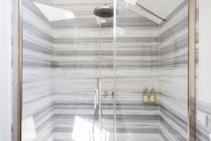 una doccia con porta in vetro in bagno di Villa Rossella a Locarno