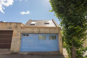 a garage with a blue door and a roof at The Blue Door in Bath