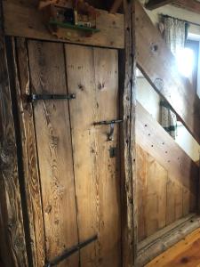 stare drewniane drzwi w pokoju z drewnianą podłogą w obiekcie Maison Angèle w mieście Saint-Nicolas