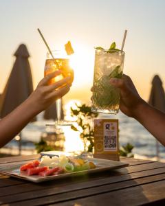a table with two drinks and a plate of food at Golden Star City Resort in Perea