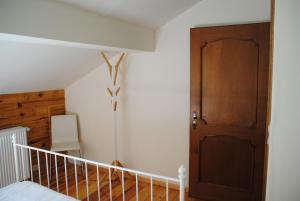 een slaapkamer met een houten deur en een trap bij Gite chez Phil in Durbuy