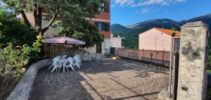 un patio con 2 sillas blancas y una sombrilla en Villa Carlotta, en Isernia