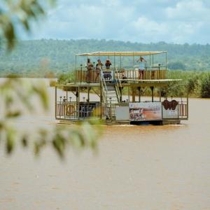 a boat on a river with people on the deck at Sefapane Lodge and Safaris in Phalaborwa +7 photos