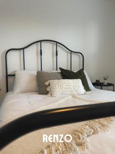 uma cama com lençóis brancos e almofadas em Spacious 2 Bedroom home in Lincoln by Renzo, Victorian Townhouse, Flexible Check-In! em Lincolnshire