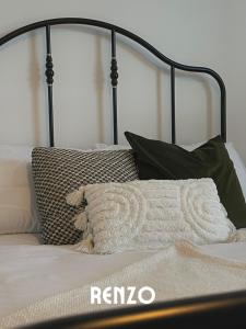 uma cama com uma moldura preta e almofadas em Spacious 2 Bedroom home in Lincoln by Renzo, Victorian Townhouse, Flexible Check-In! em Lincolnshire