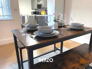 a wooden table with bowls and glasses on it at Spacious 2 Bedroom home in Lincoln by Renzo, Victorian Townhouse, Flexible Check-In! in Lincolnshire
