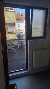 uma porta aberta para uma varanda com um pátio em Apartments Ho30 em Stuttgart