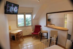 a living room with a tv and a table and chairs at Le Relais in Düsseldorf