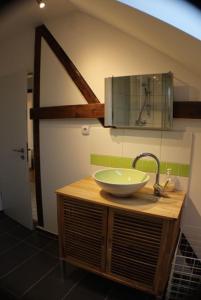 a bathroom with a bowl sink on a wooden counter at Le Relais in Düsseldorf