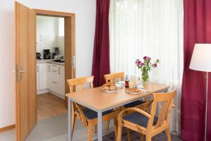 a dining room with a table and chairs and a kitchen at Wildbach Appartement in Ober-Hambach