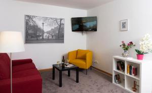 a living room with a red couch and a yellow chair at Wildbach Appartement in Ober-Hambach