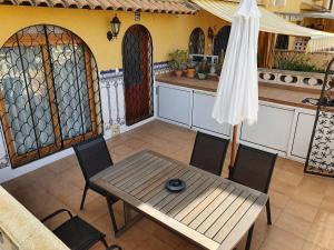 - une table, des chaises et un parasol dans la cuisine dans l'établissement Apartamento Alkabir Playa, à El Campello