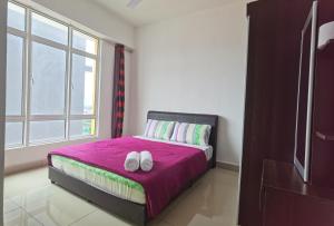 a bedroom with a bed with two white shoes on it at Ipoh Majestic R&C Homestay 2 & 3 in Ipoh +71 photos