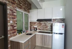 a kitchen with white appliances and a brick wall at Ipoh Majestic R&C Homestay 2 & 3 in Ipoh