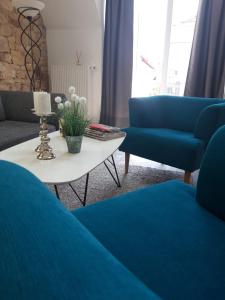 a living room with blue couches and a table at Die Französin - Ingo Telschow & Catherine Tempier Gbr in Deidesheim