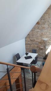 a living room with a table and a stone wall at Die Französin - Ingo Telschow & Catherine Tempier Gbr in Deidesheim