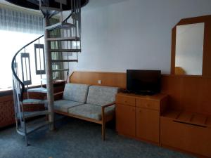 un soggiorno con scala, sedia e specchio di Mezonet Almberg Apartmany JaJ a Mitterfirmiansreut
