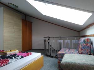 um quarto com uma cama, uma cadeira e uma clarabóia em Mezonet Almberg Apartmany JaJ em Mitterfirmiansreut