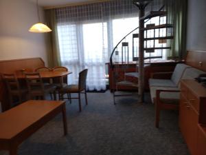 un soggiorno con divano, tavolo e sedie di Mezonet Almberg Apartmany JaJ a Mitterfirmiansreut