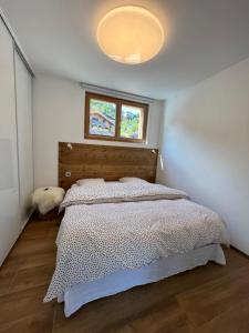 ein Schlafzimmer mit einem großen Bett mit Fenster in der Unterkunft Magnifique appartement classé 4 étoiles avec Sauna et terrasse dans chalet in La Bresse