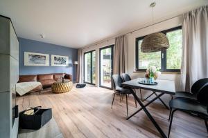 uma sala de estar com uma mesa e um sofá em Haus Schlehe -Domizil am Ostseewald em Zingst