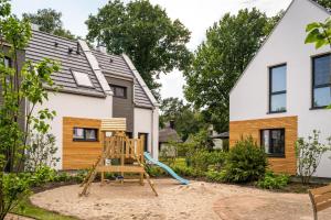 un parque infantil en el patio trasero de una casa en Haus Schlehe -Domizil am Ostseewald en Zingst