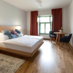 a bedroom with a bed and a table and a window at Hotel Tři knížata in Jihlava