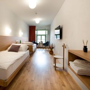 a hotel room with two beds and a desk at Hotel Tři knížata in Jihlava