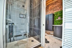 W łazience znajduje się prysznic ze szklanymi drzwiami. w obiekcie * Le LoFt Des MysTèrEs * w mieście Maintenon