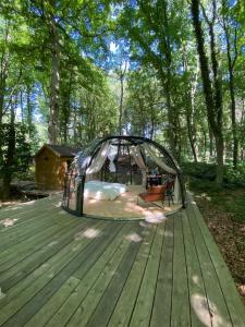 Le Dôme de Namur - Une nuit insolite dans les bois في Champion: خيمة على سطح خشبي في الغابة