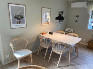 uma sala de jantar com uma mesa branca e cadeiras em Skog Fegen nära Ullared em Fegen