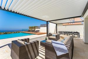 a patio with wicker furniture and a swimming pool at Chalet Golf Costa Adeje 3A003 in Adeje
