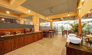 a restaurant with wooden cabinets and tables and chairs at Treebo Trend Worldtree Manyata Thanisandra in Bangalore