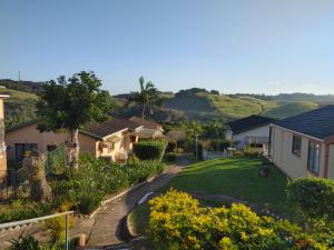 a view of a house with a garden at Cheerful 2 bedroom cottage with a communal pool in Hibberdene