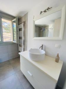 a white bathroom with a sink and a mirror at Aelio in Raches