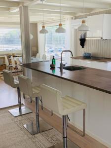 a kitchen with a large counter with chairs and a table at Renovated sea facing cottage on the Eidanger fjord in Porsgrunn