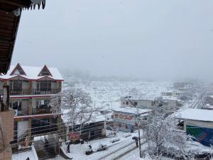 eine schneebedeckte Stadt mit einem Hafen in der Ferne in der Unterkunft Country Side Home Stay in Rānīkhet