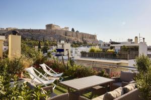 a patio with chairs and a table on a roof at Acropolis Panorama Residence in Athens