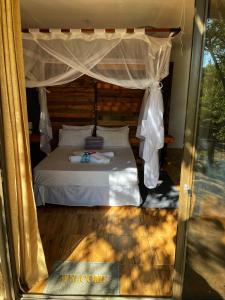 sypialnia z łóżkiem z baldachimem w obiekcie Kaoko Mopane Lodge & Campsite w mieście Opuwo