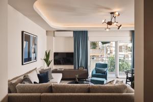 a living room with a couch and two blue chairs at Acropolis Panorama Residence in Athens