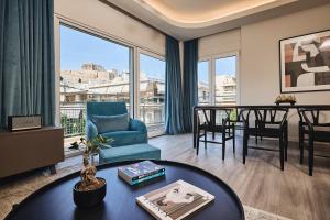 a living room with a blue chair and a table at Acropolis Panorama Residence in Athens