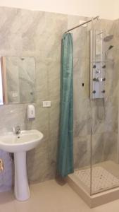 La salle de bains est pourvue d'un lavabo et d'une douche. dans l'établissement Hotel Torvaianica, à Torvaianica