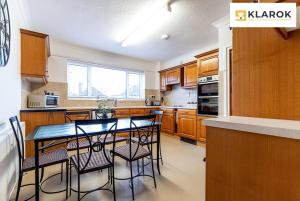 a kitchen with wooden cabinets and a table and chairs at LONG STAYS 30pct OFF - Spacious 3 Bed with Parking & Keyless Access By Klarok Short Lets & Serviced Accommodation in Peterborough
