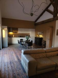 een woonkamer met een bank en een tafel en een keuken bij Appartement de charme dans ancienne cave à vin in Le Boulou
