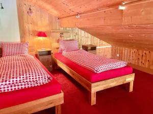 2 letti in una camera con pareti in legno di BnB Guesthouse Lusi a Frauenkirch