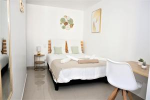 Habitación blanca con cama y escritorio en #Golden Dream's By Nogar'Homes -Wi-Fi-Netflix-Climatisation-Parking, en Nogaro