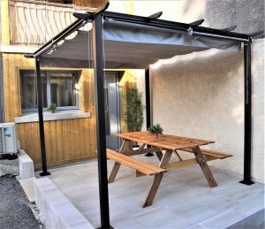 una mesa de picnic bajo un dosel en un patio en #Golden Dream's By Nogar'Homes -Wi-Fi-Netflix-Climatisation-Parking, en Nogaro
